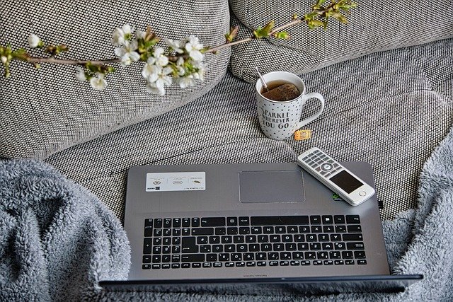 Passive Income A Laptop Remote And Tea Cup On A Sofa