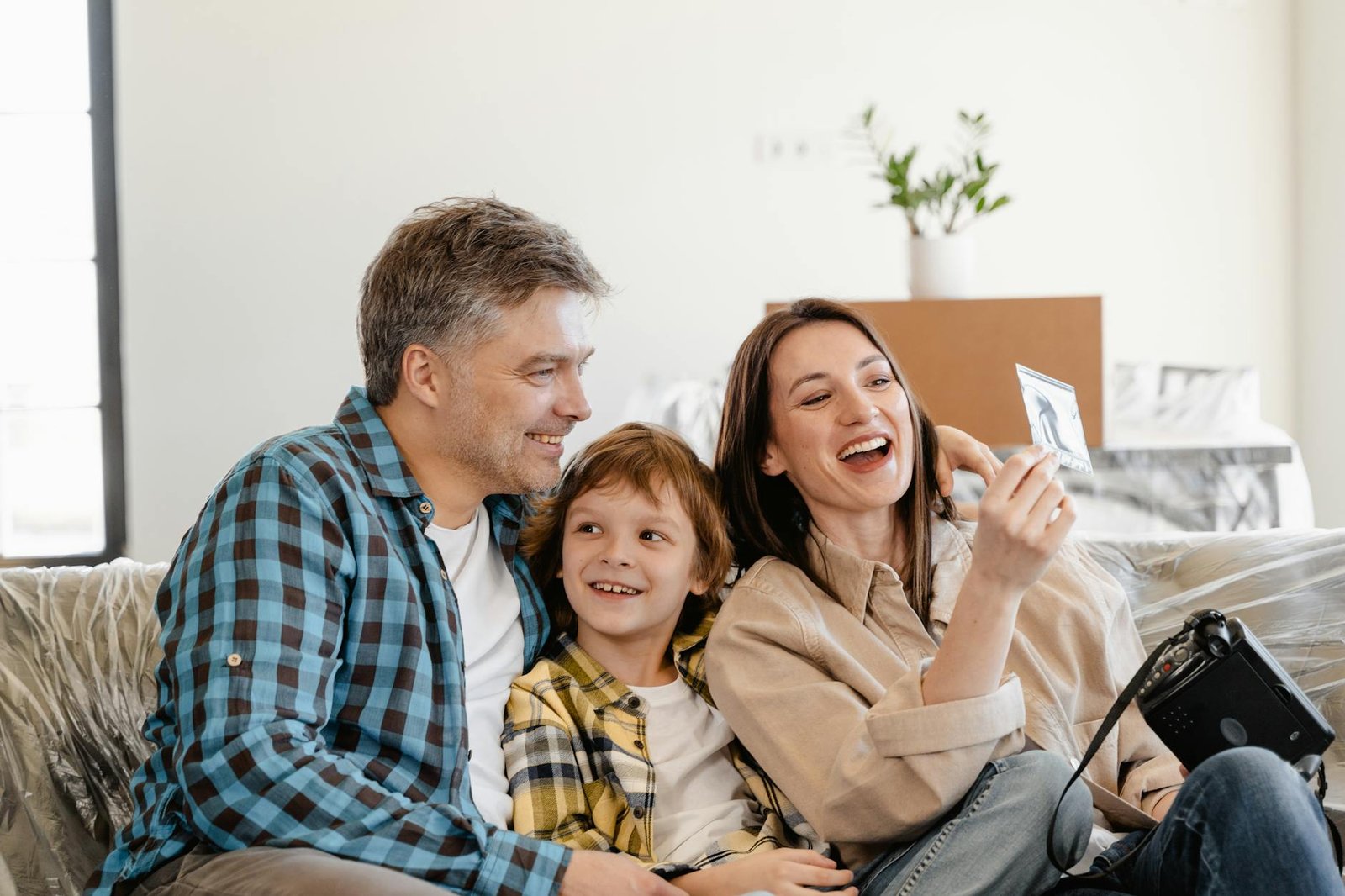 man and woman smiling while holding white smartphone